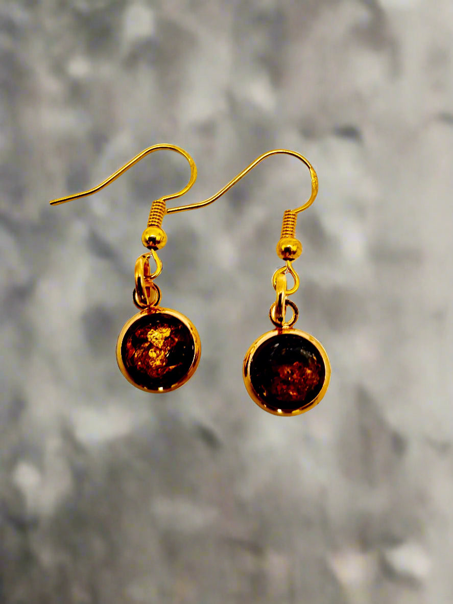 Gold earrings with amber-colored stones on a white background