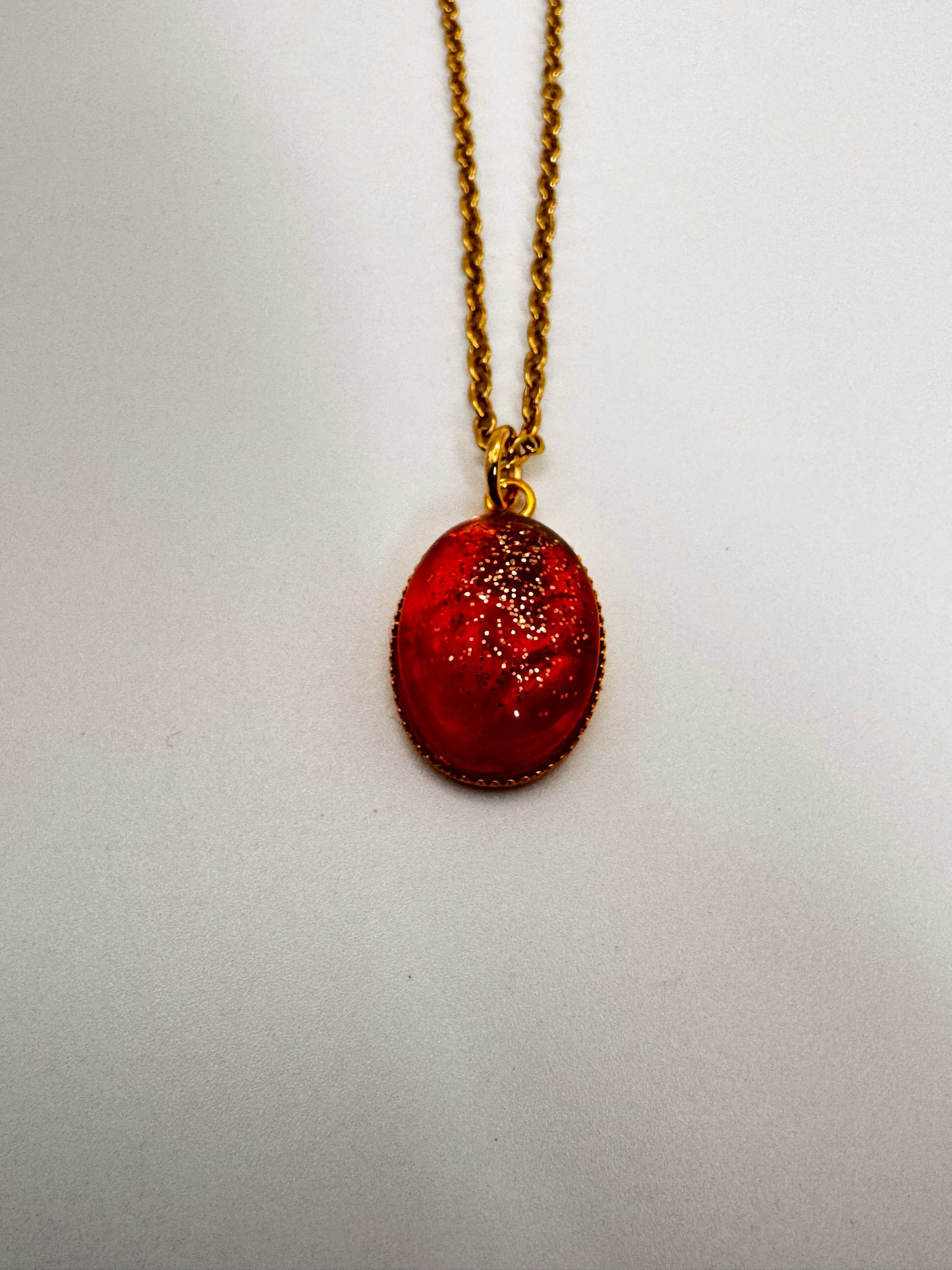 Red pendant necklace on a light gray background