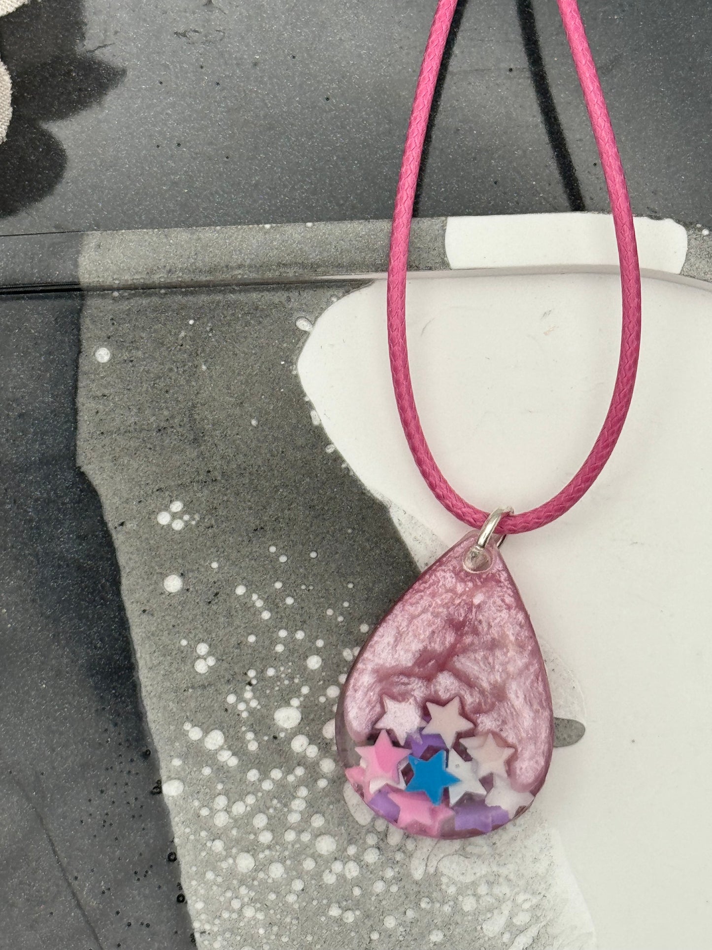 Pink teardrop pendant with stars
