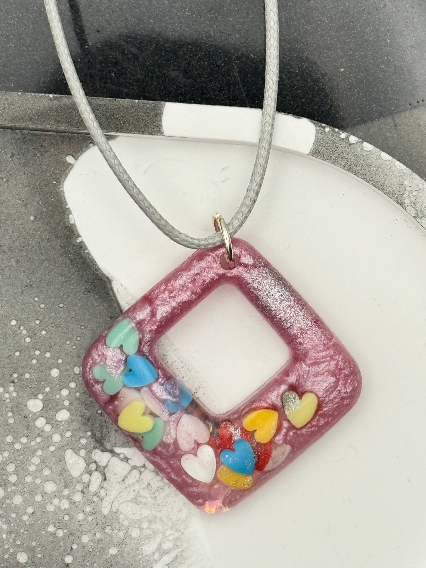 Pink pendant with multicolored hearts